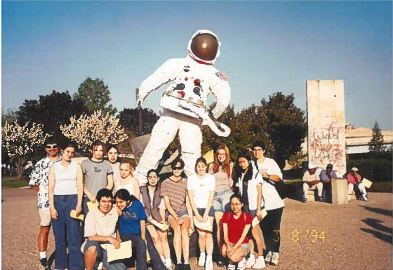 Students posing in front of an astronaut statue